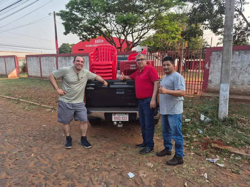 Una calle recién empedrada con materiales de alta calidad y vecinos supervisando la obra con cascos blancos.