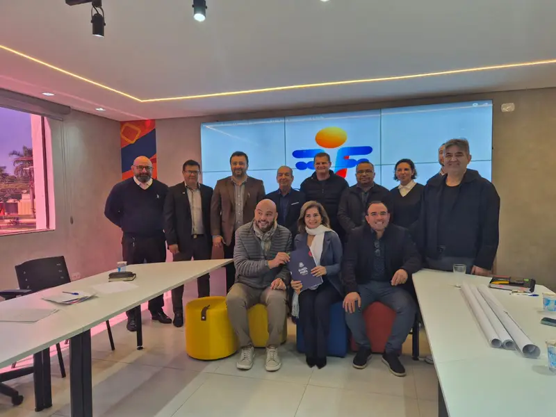 Un centro comunitario moderno con pantallas táctiles y jóvenes colaborando en estaciones de trabajo de alta tecnología.