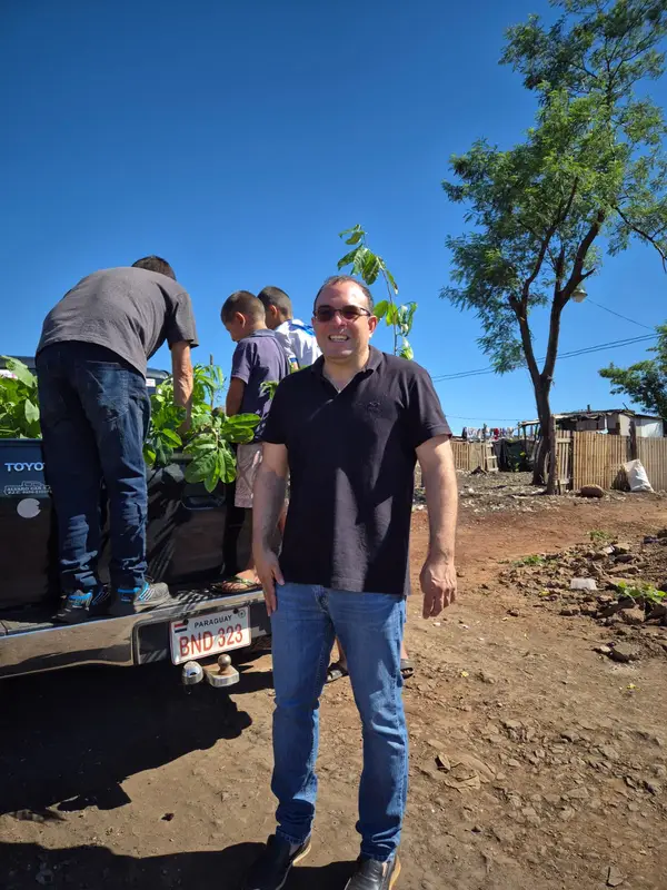 Ciudadanos trabajando en un huerto urbano tecnológico bajo la luz del atardecer.